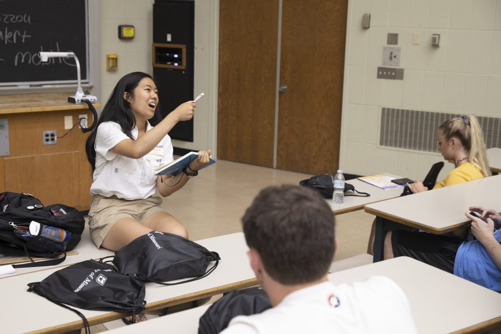 A student ambassador answers student questions in a small group at a Summer Welcome event.